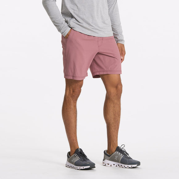 man wearing marsala vuori shorts with a grey shirt and dark grey sneakers