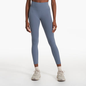 woman wearing blue yoga leggings and white tennis shoes