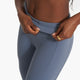 close up of a woman opening a pocket in blue yoga leggings 