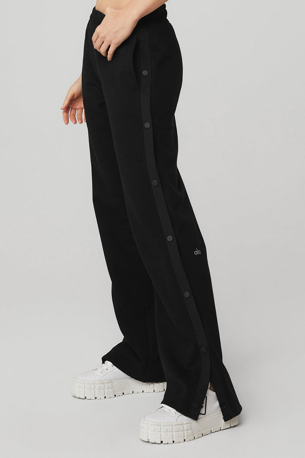 Female model wearing Alo Yoga black snap pant 