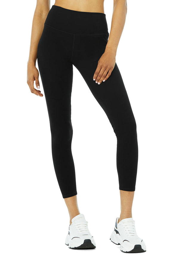 Black female model wearing black Alo leggings