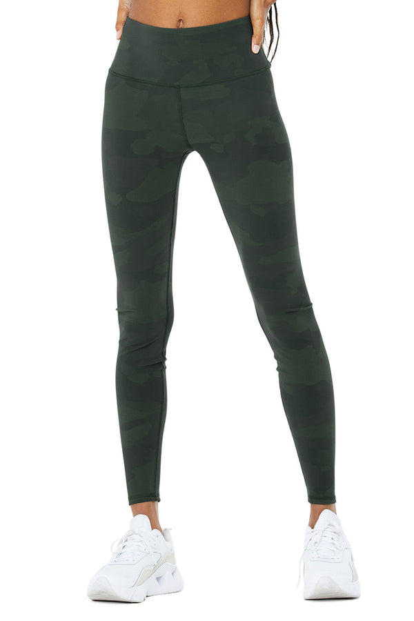 Female model wearing green camo leggings from alo yoga