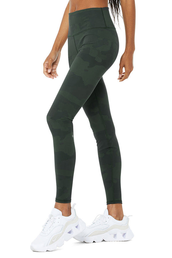 Female model wearing green camo leggings from alo yoga