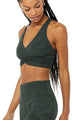 Female model wearing green camo leggings from alo yoga