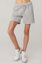 Load image into Gallery viewer, Female model wearing loose gray shorts from Alo Yoga