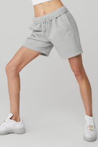 Female model wearing loose gray shorts from Alo Yoga