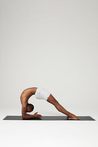 A yogi posing on a black Alo Air Yoga Mat