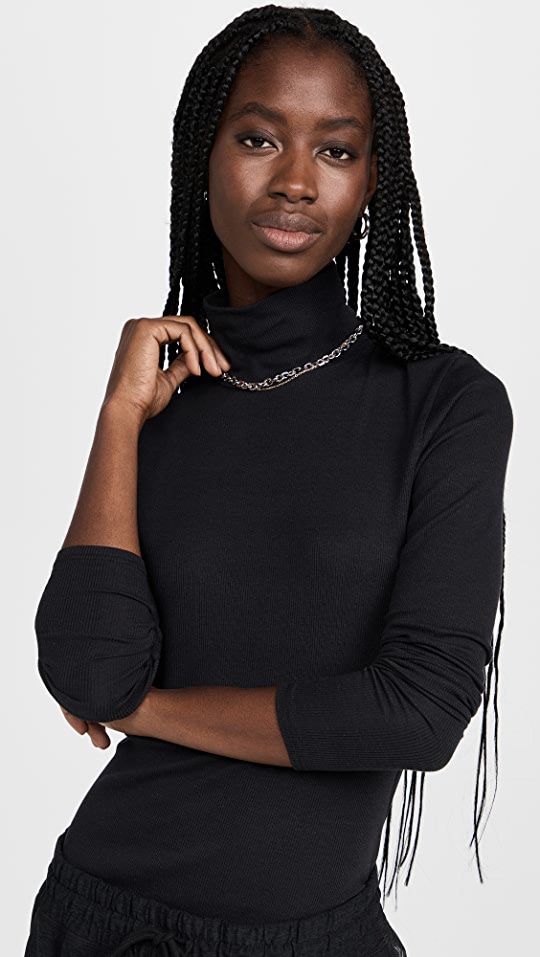 Female model wearing essential ribbed turtleneck from beyond yoga