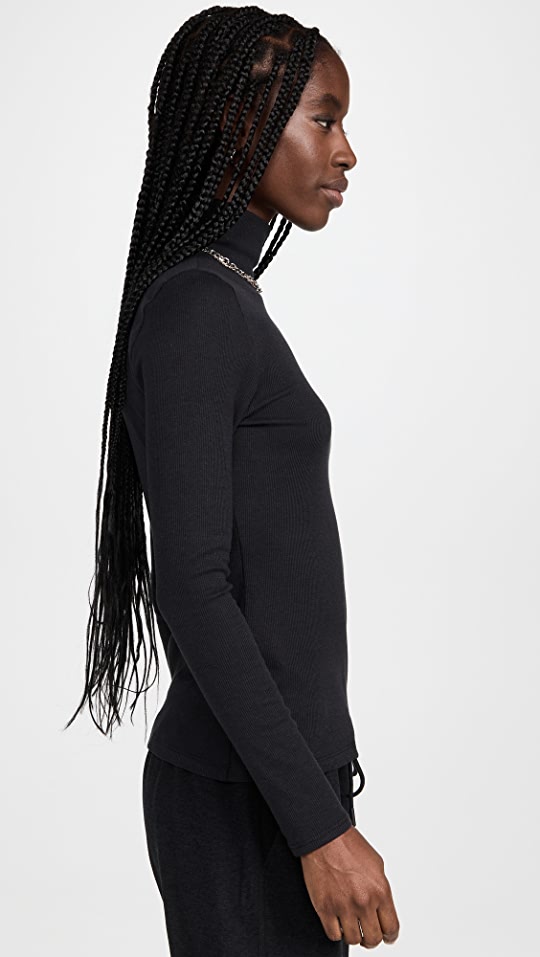 Female model wearing essential ribbed turtleneck from beyond yoga
