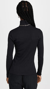 Female model wearing essential ribbed turtleneck from beyond yoga