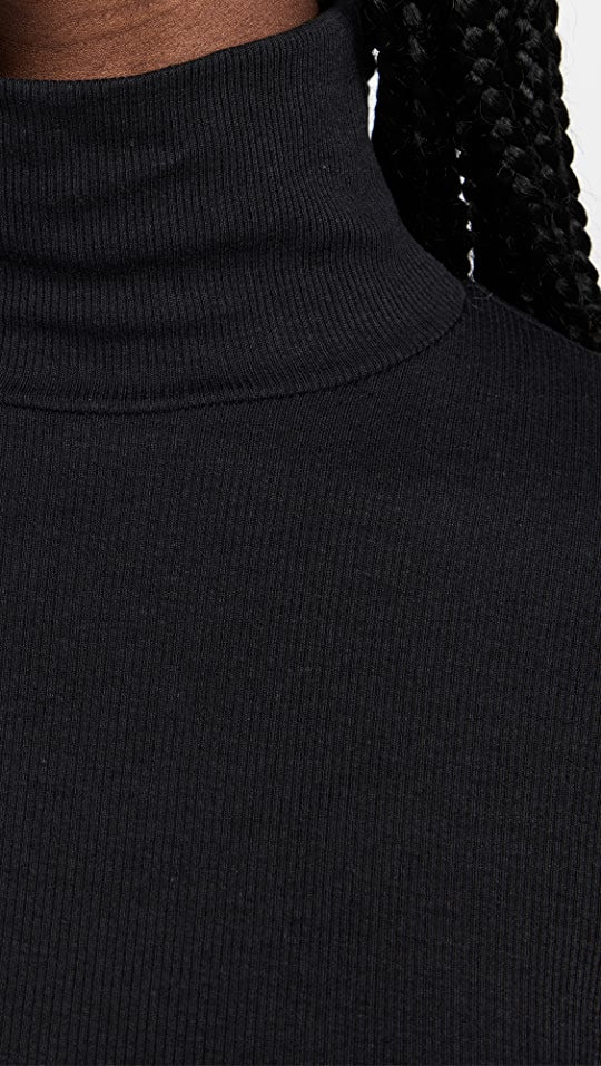 Female model wearing essential ribbed turtleneck from beyond yoga
